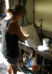 Jana sanding primed canvases